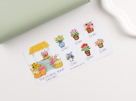 Floral-themed savings challenge with illustrations of flowers and a flower shop on a white surface.