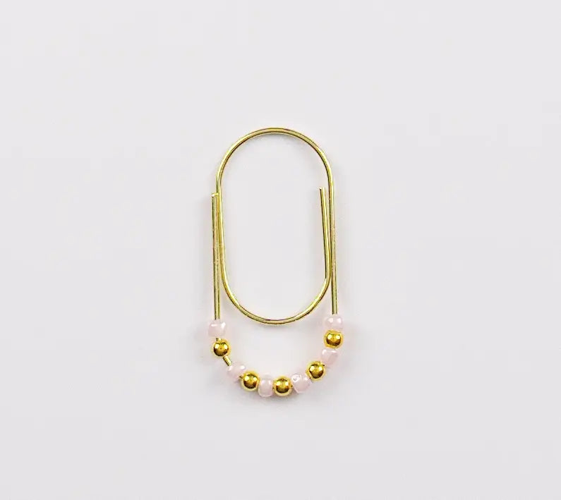 Gold and pearl paper clip charm on a white background