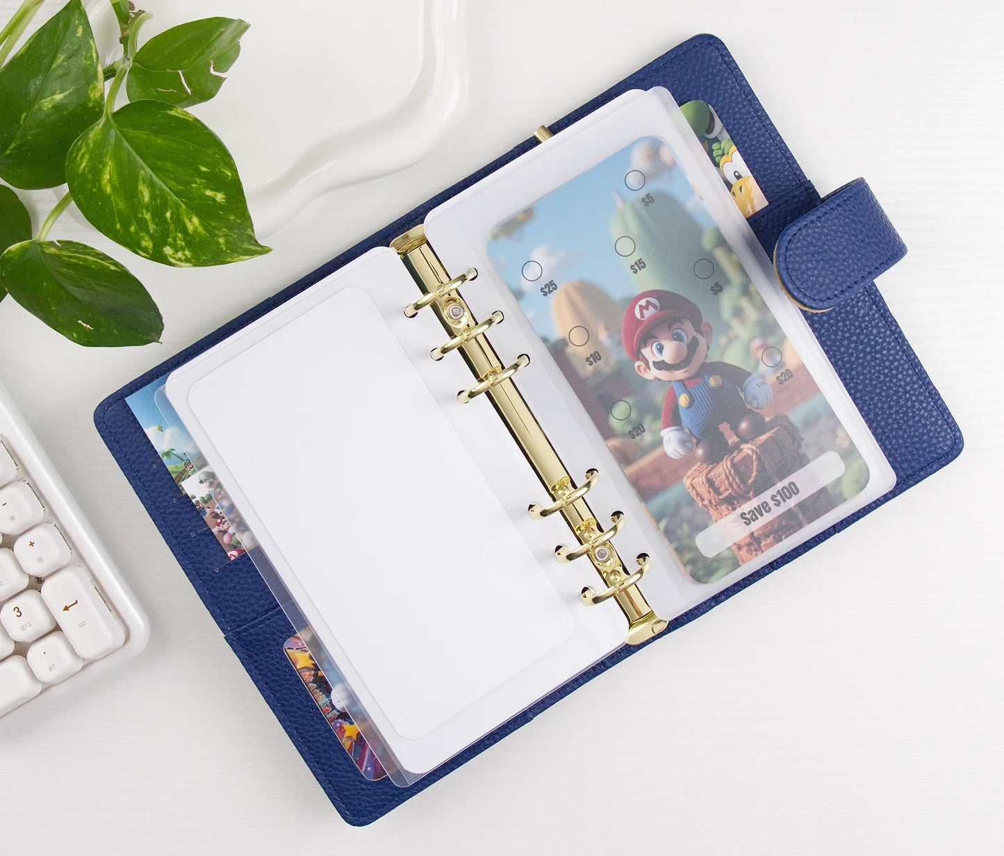 Blue binder with cartoon character design on a white surface with a plant in the corner.