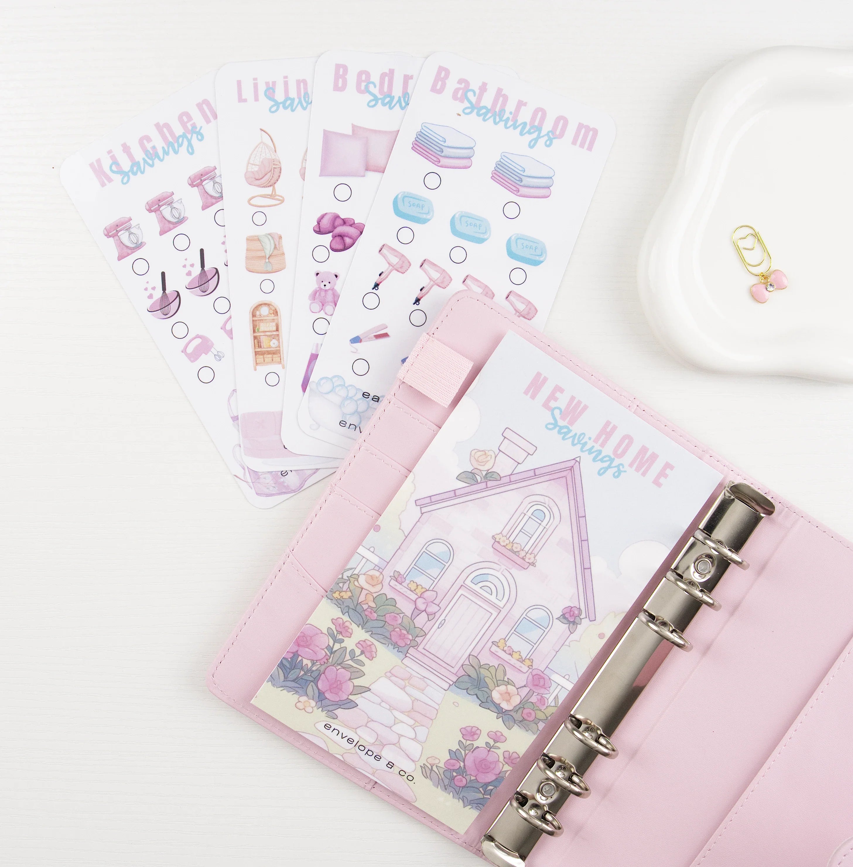 Flat lay of Valentine-themed savings challenge cards with hearts, envelopes, and a tic-tac-toe design.