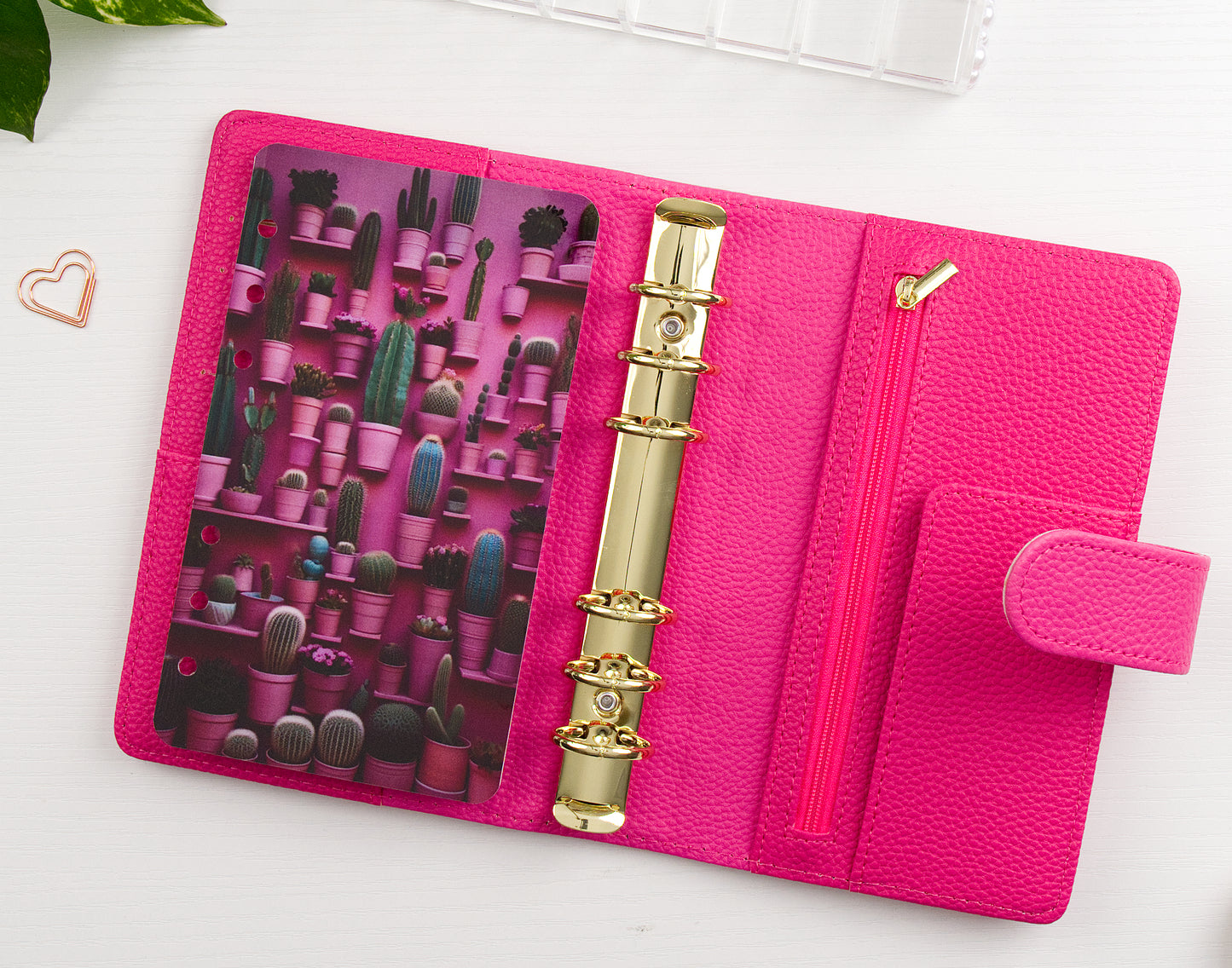Pink binder with gold rings and cactus-themed design on a white background