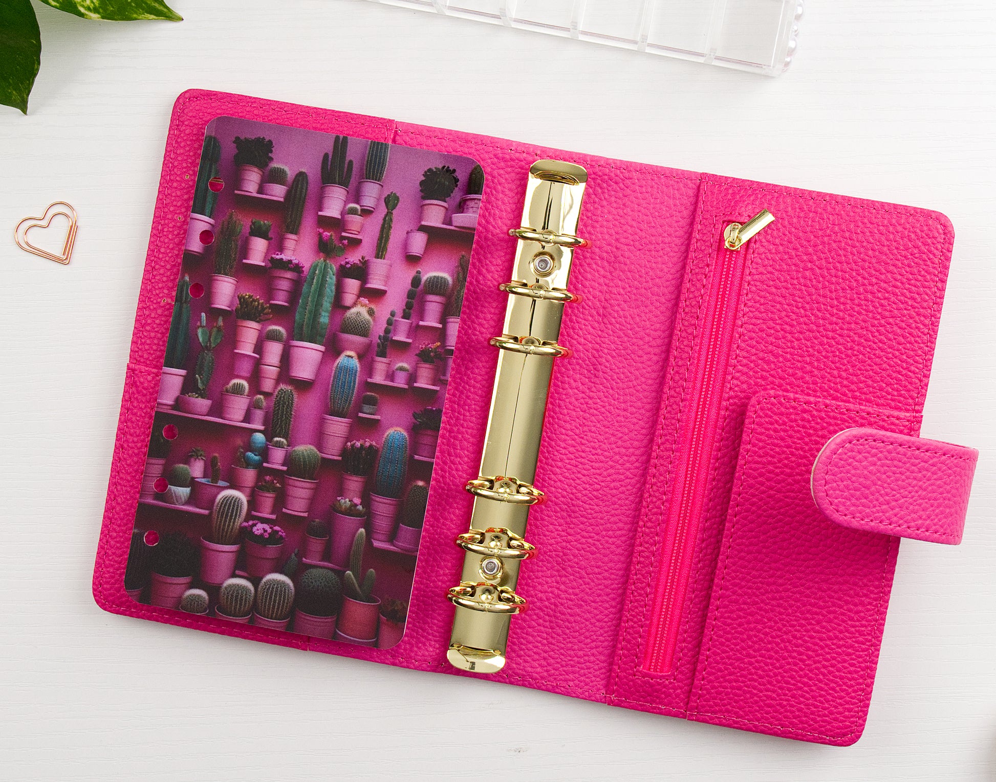 Pink binder with gold rings and cactus-themed design on a white background