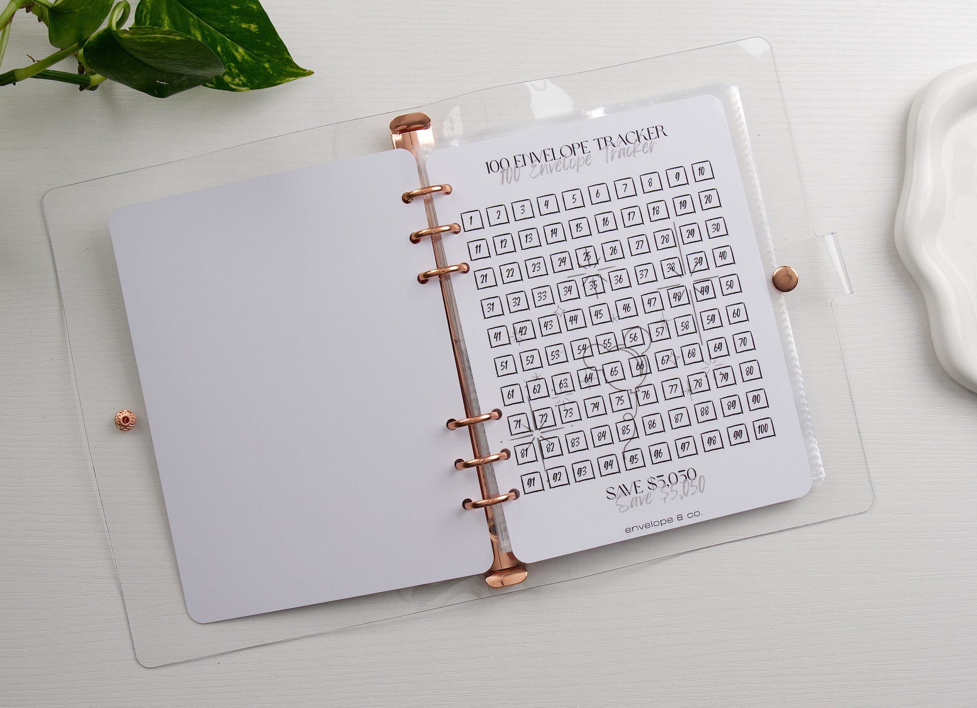 100 envelope tracker page inside a binder on a white background