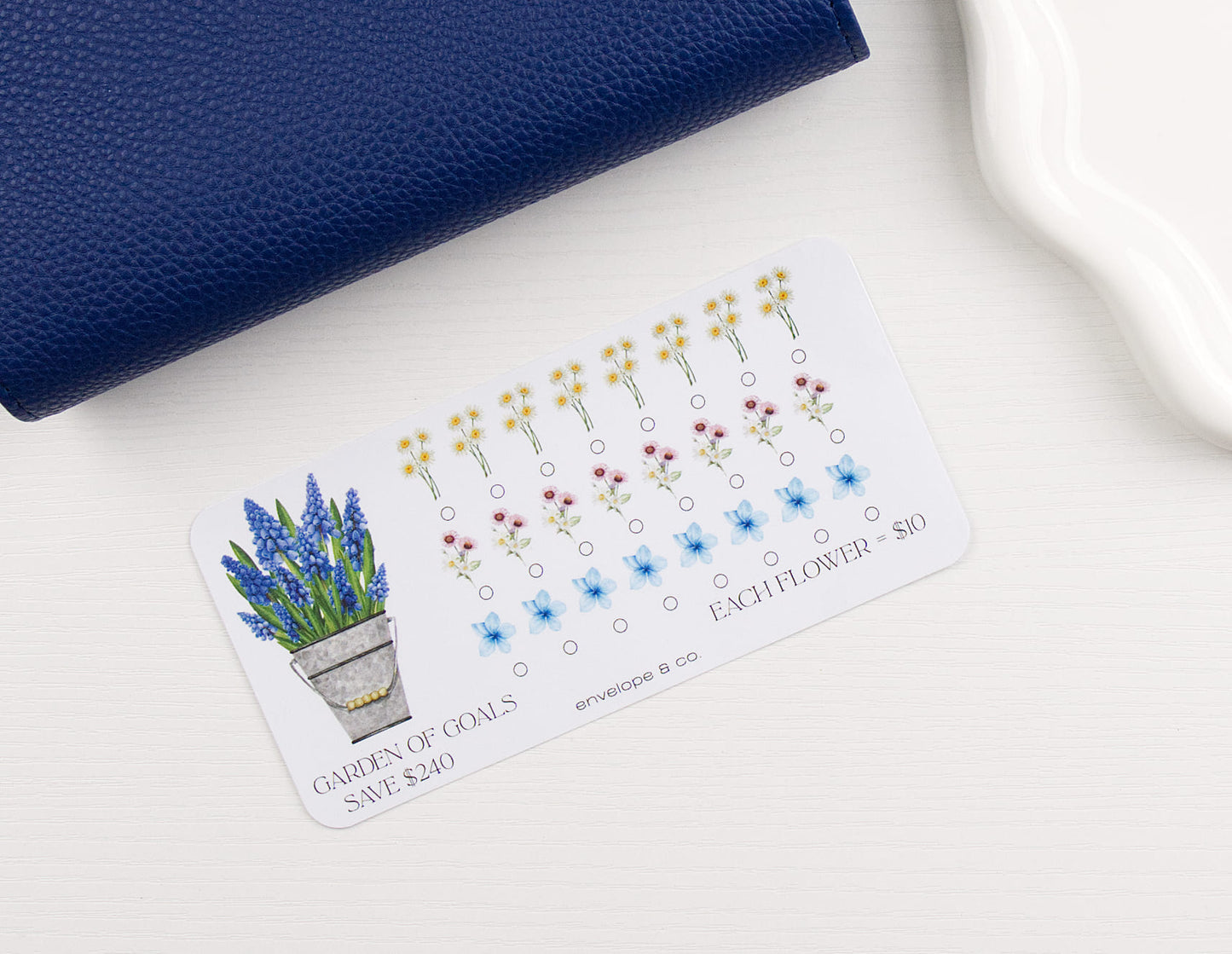 Floral themed savings challenge on white background with blue binder in corner