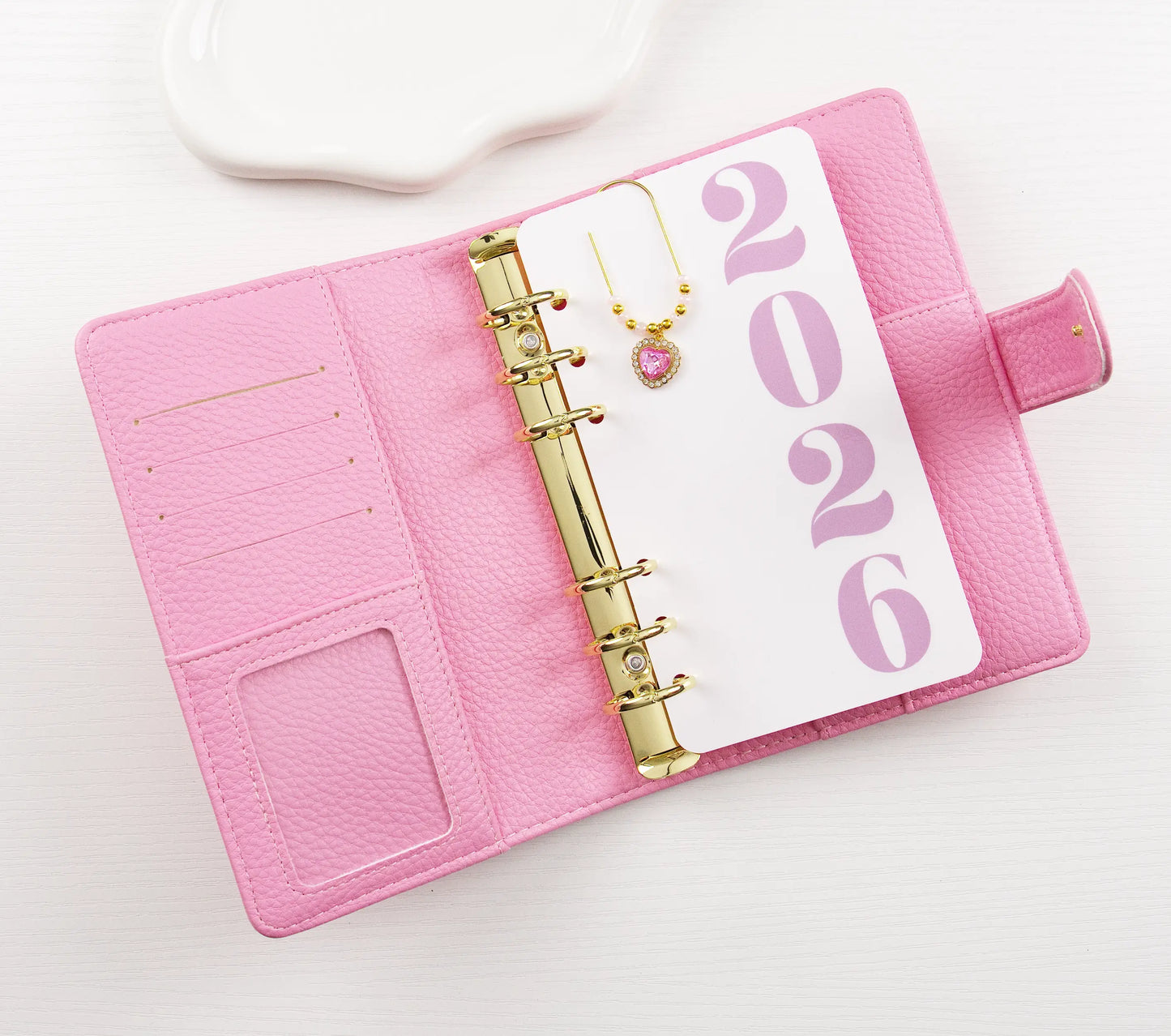 Pink binder with gold binding and '2026' on a white background