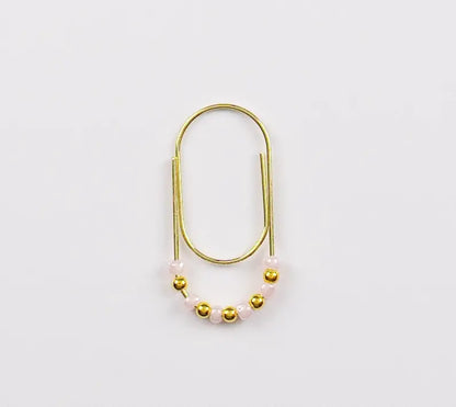 Gold and pearl paper clip charm on a white background