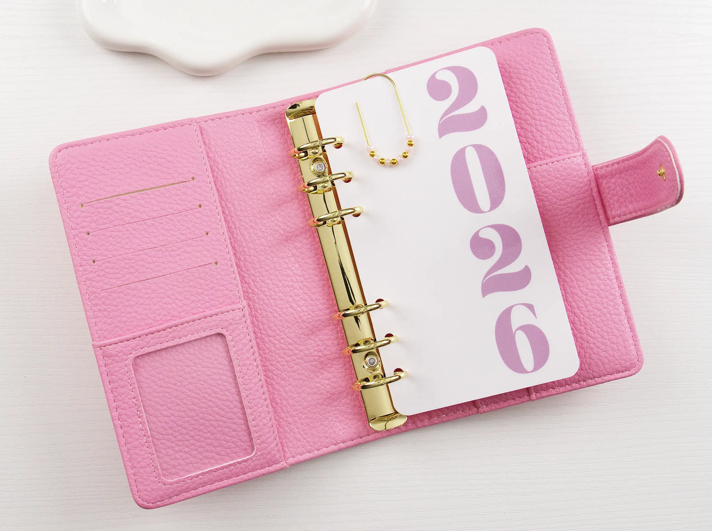 Pink binder with a '2026' page on a white background