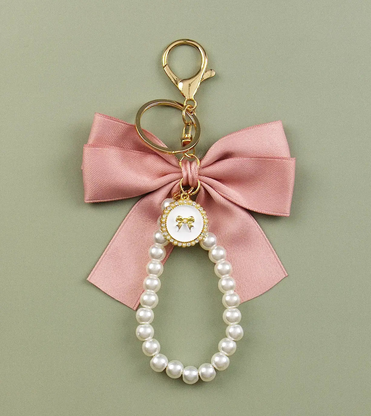 Keychain charm with pink bow and pearls on a green background