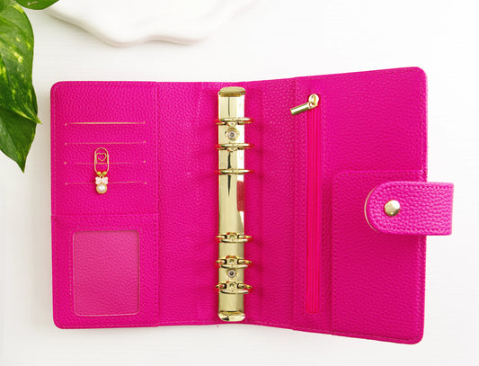 Pink binder with gold binding on a white background