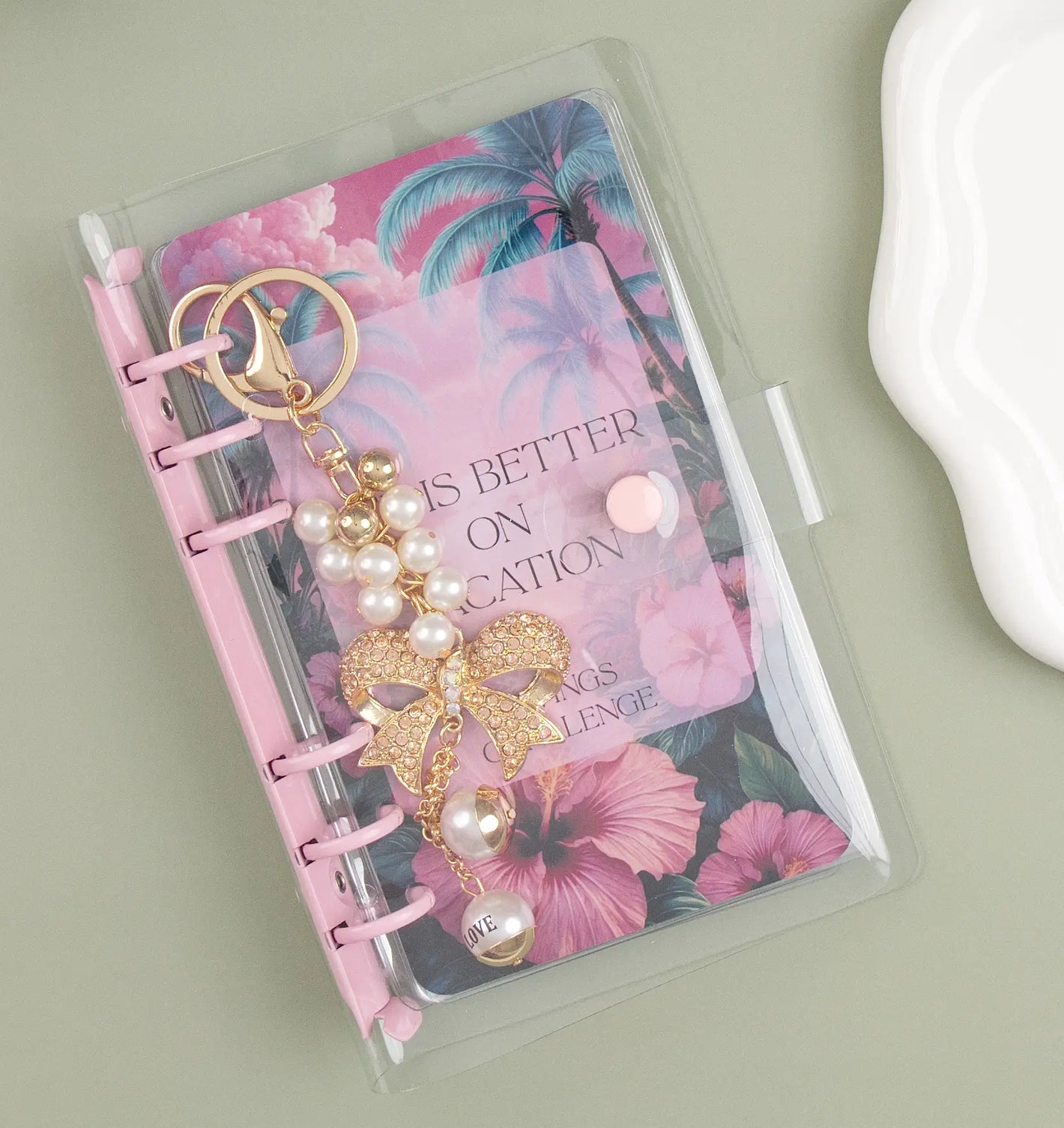Keychain with pearls inside a binder with a pink floral dashboard