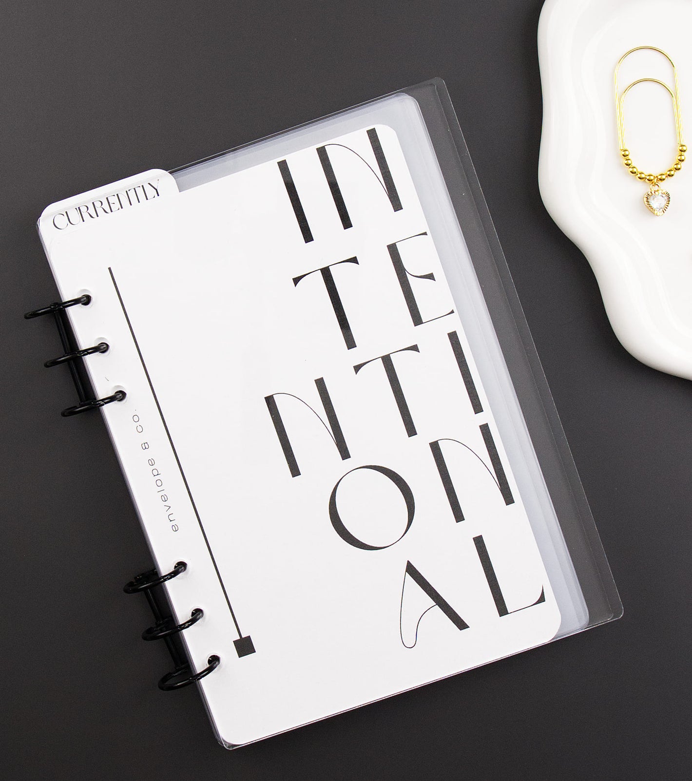 Binder with 'INTENTIONAL' design on a dark surface