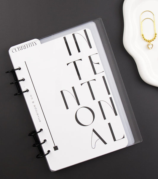 Binder with 'INTENTIONAL' design on a dark surface