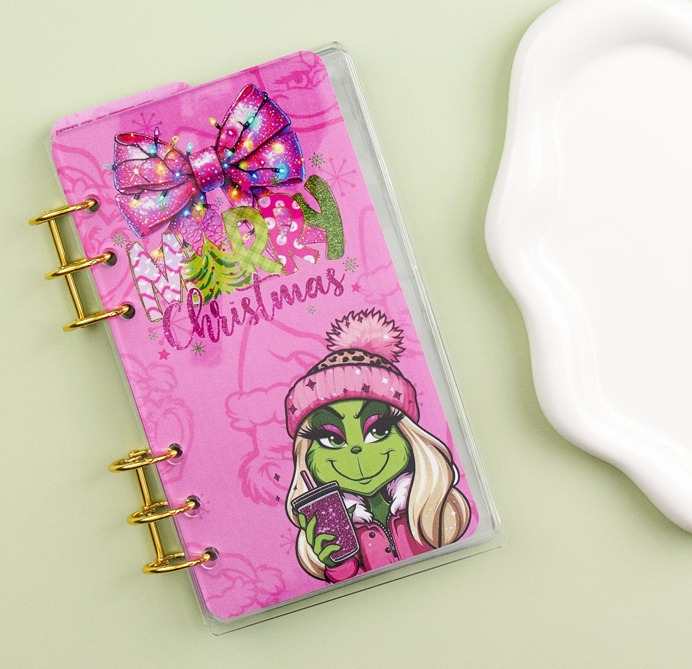 Pink binder with green character design on a light green background