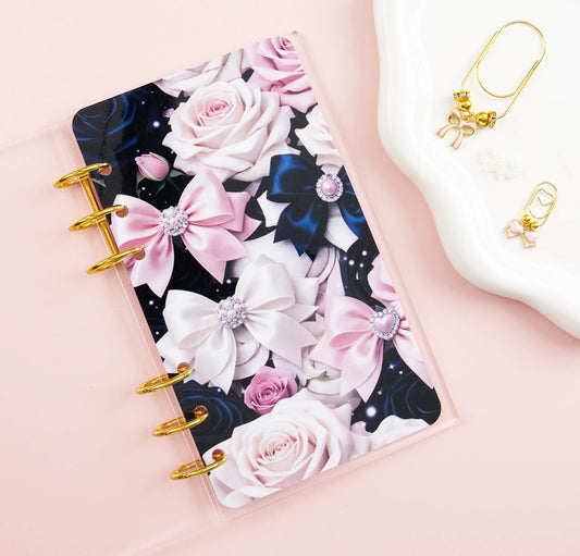 Clear binder with floral and bow design on a pink background