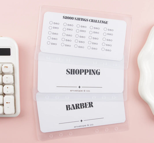 Three labeled inserts on a pink surface with a calculator and white tray.