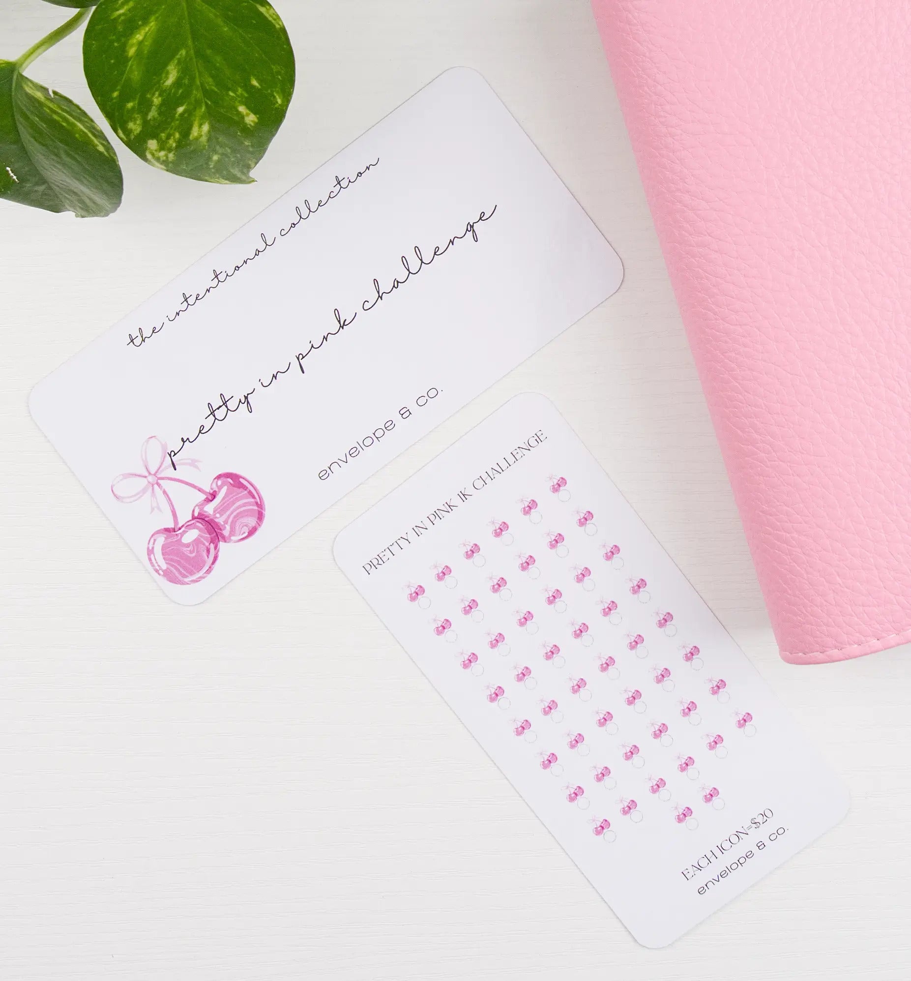 Pink cherry-themed savings bundle items on a white surface with a pink binder and green leaves in the background.