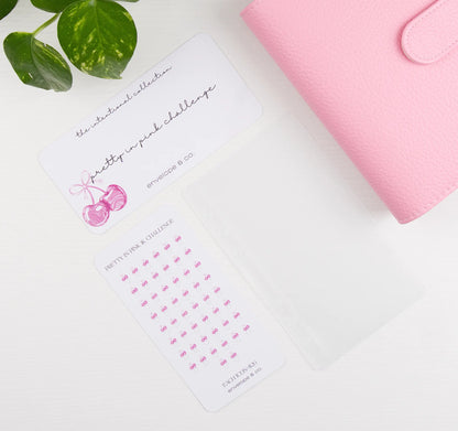 Pink binder with a cherry-themed savings bundle on a white surface
