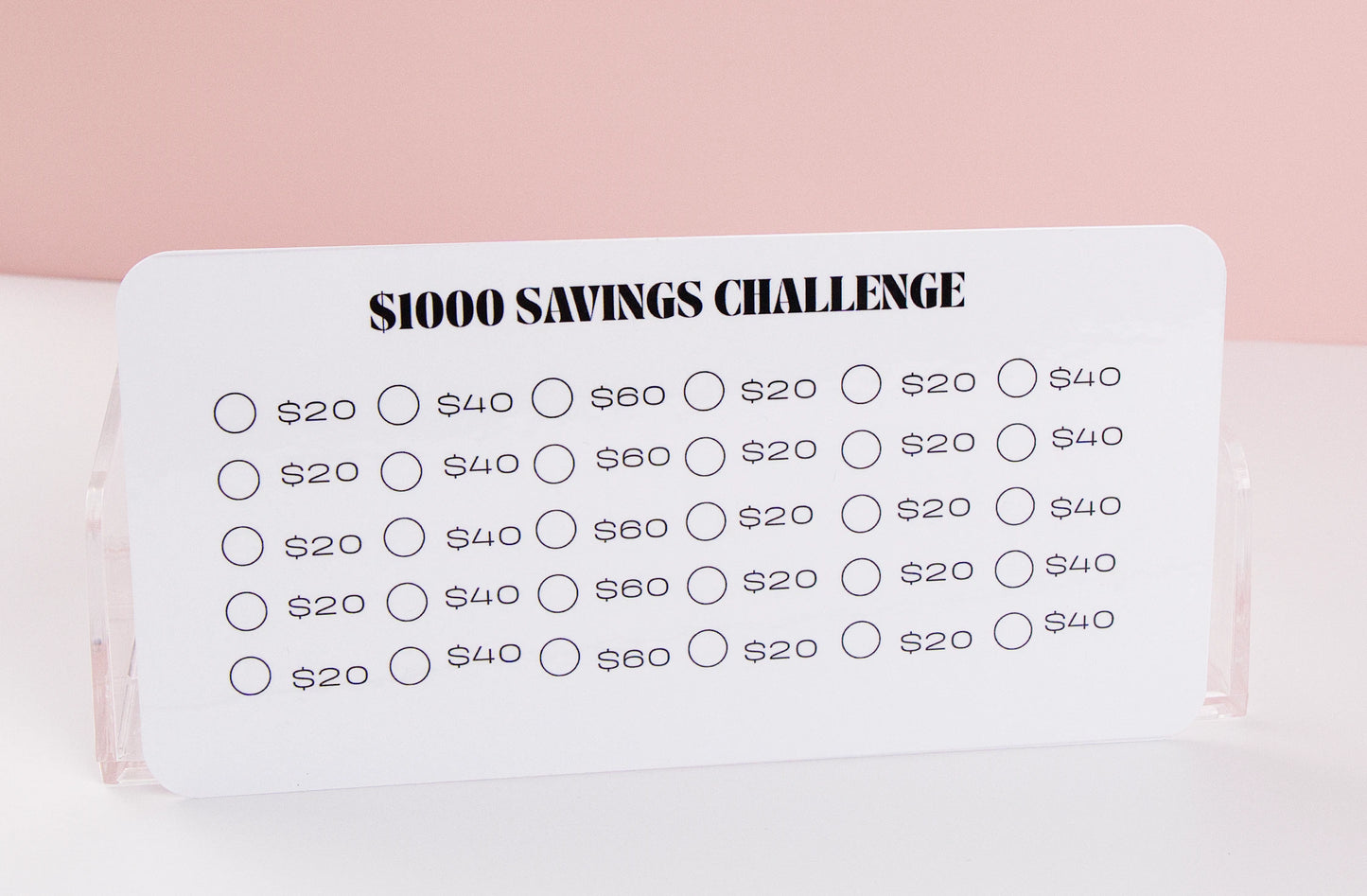 $1,000 Savings challenge tracker with various savings amounts on a pink background