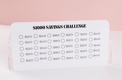 $1,000 Savings challenge tracker with various savings amounts on a pink background