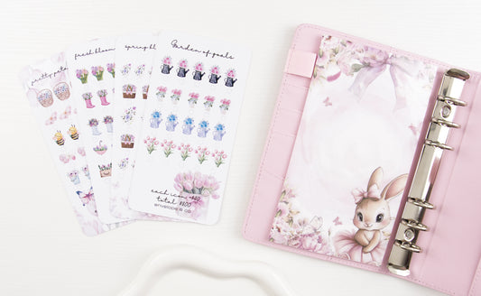 Pink binder with rabbit design dashboard and matching savings trackers on a white background