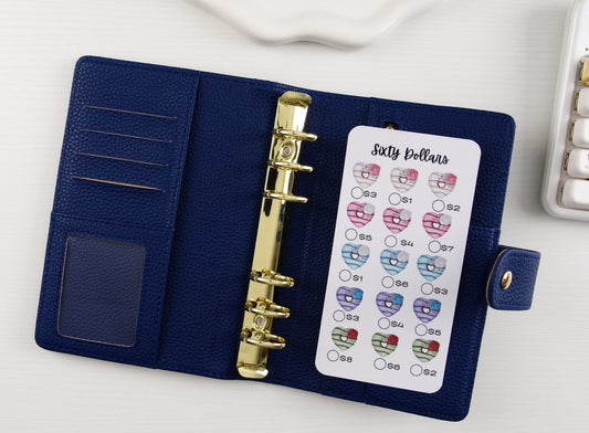 Blue binder with gold binding and heart-themed savings challenge on a white background